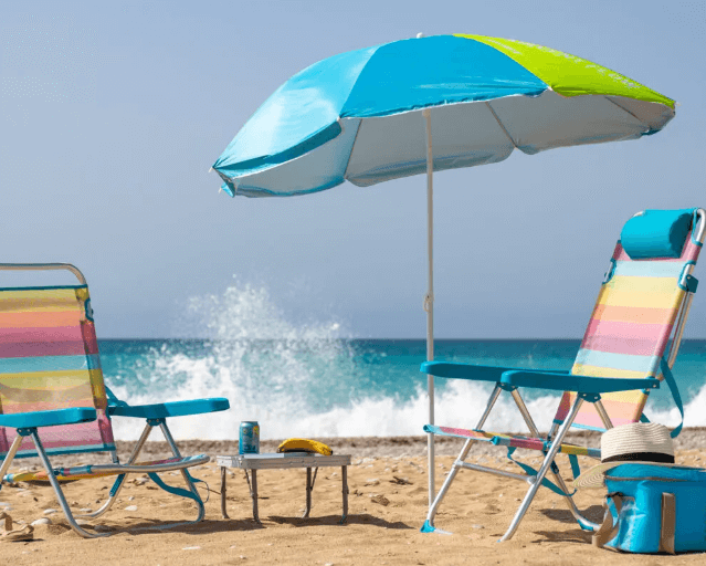 campamento montado en la playa con su mesa plegable playa pequeña, dos sillas de playa y una sombrilla para pasar el mejor día de playa